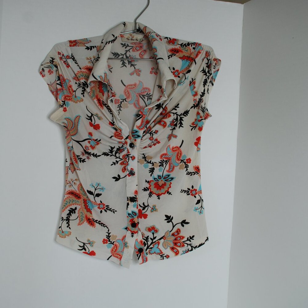 Women's blouse white with a floral pattern in shades of blue, red, and black.